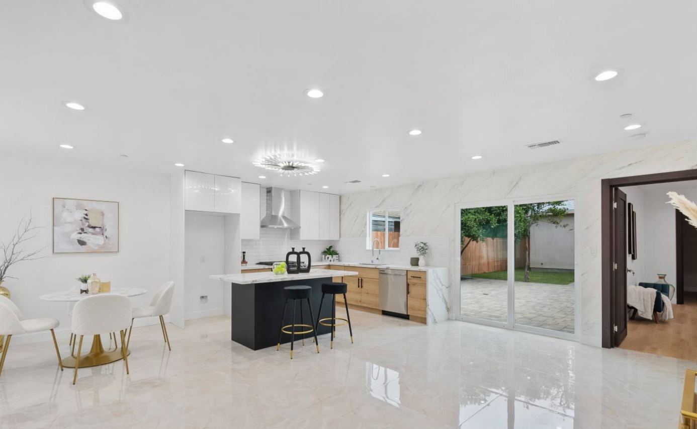 Open-concept kitchen remodel with marble backsplash and island